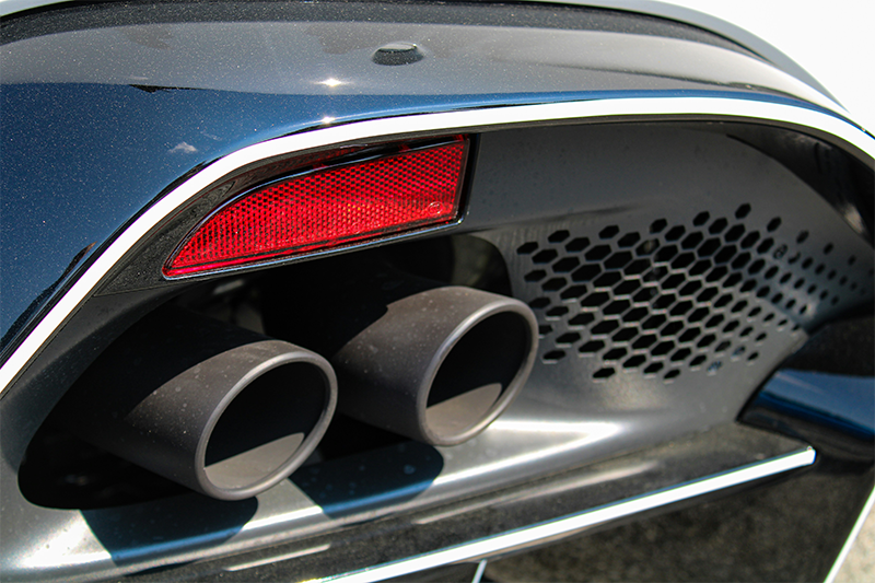 The tailpipes of a blue passenger vehicle.