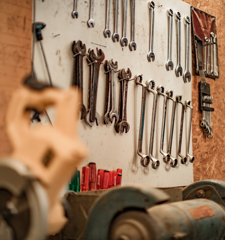 A hobbyist workshop or home garage shown with the tool and equipment setup to work on auto repairs and renovation projects.