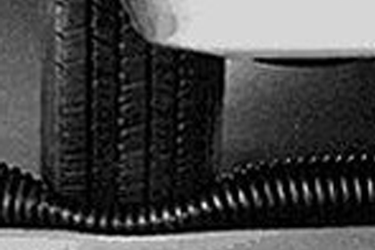 A car tire driving over a crushproof exhaust hose.